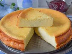 Tarta de queso y limón al horno, dorada y esponjosa, con una porción servida.