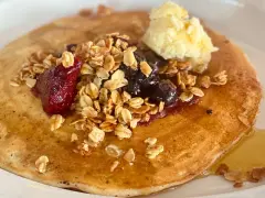 Deliciosos crepes con harina de almendras, cubiertos con granola, frutos rojos, arándanos y una porción de mantequilla.