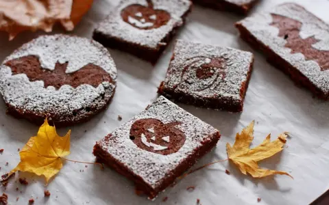 Deliciosos brownie halloween con calabazas y murciélagos, espolvoreados con azúcar glas.