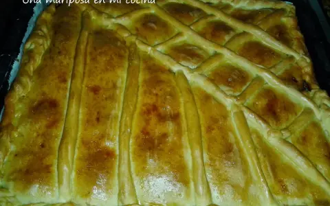Empanada marinera dorada y crujiente, lista para disfrutar. Su masa cubierta con un enrejado perfecto promete un sabor delicioso.