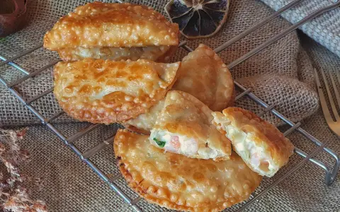 Empanadillas de gambas doradas y crujientes, rellenas de marisco y cremosidad, listas para disfrutar.