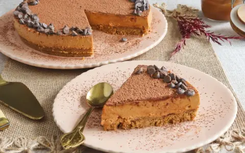 Deliciosa tarta de dulce de leche y galletas, cubierta de cacao y chispas de chocolate. ¡Un postre irresistible!