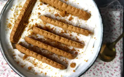 Delicioso postre con yogur natural sin horno, decorado con galletas crujientes y migas.