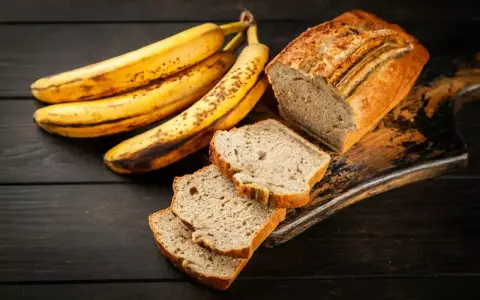 Plátanos maduros junto a un delicioso banana bread recién horneado, con rebanadas listas para disfrutar.