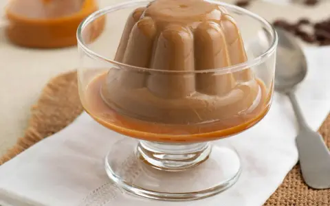 Deliciosa panna cotta de café, con un suave caramelo líquido, servida en copa de cristal.