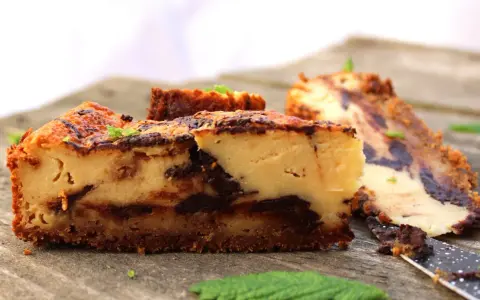 Tarta de queso con chocolate, con trozos de chocolate oscuro y una base crujiente. Perfecta para los amantes del dulce.