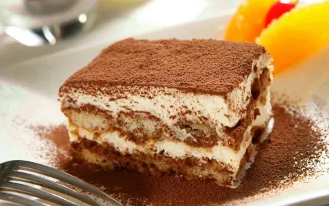 Delicioso tiramisú con mascarpone, espolvoreado con cacao. Una porción perfecta para disfrutar de esta clásica receta italiana.