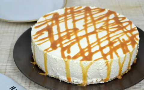 Tarta de queso con leche condensada, cubierta de caramelo líquido, lista para disfrutar.