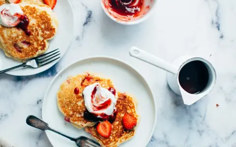 Deliciosas tortitas con fresas y nata, listas para servir. Aprende como hacer tortitas perfectas para el desayuno.