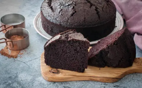Un delicioso bizcocho de chocolate, recién horneado, con dos porciones listas para disfrutar.