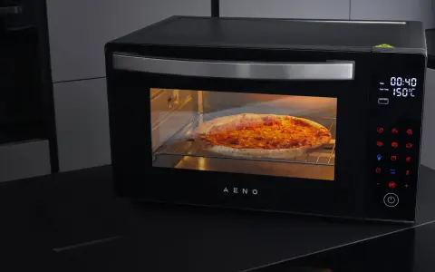 Horno AENO precalentando para pizza, con una pizza dorada en su interior.