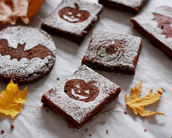 Deliciosos brownie halloween con calabazas y murciélagos, espolvoreados con azúcar glas.