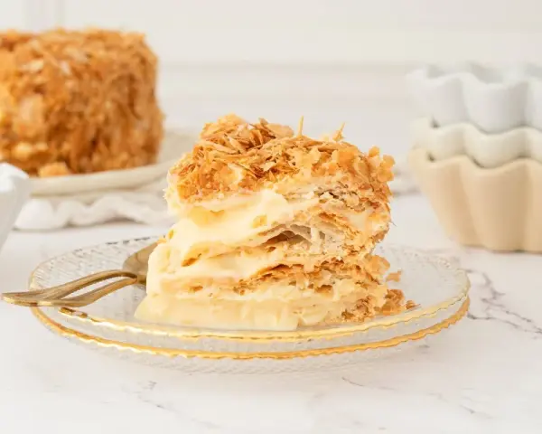 Deliciosa tarta napoleón, con capas crujientes de hojaldre y crema pastelera, lista para ser disfrutada.