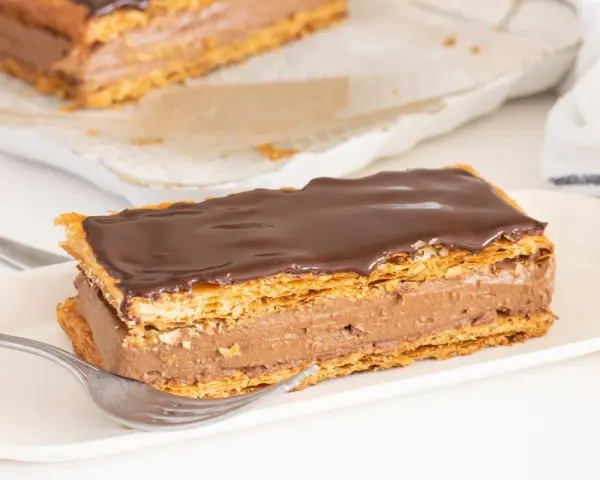 Delicioso milhojas de chocolate con capas crujientes de hojaldre y crema de cacao.