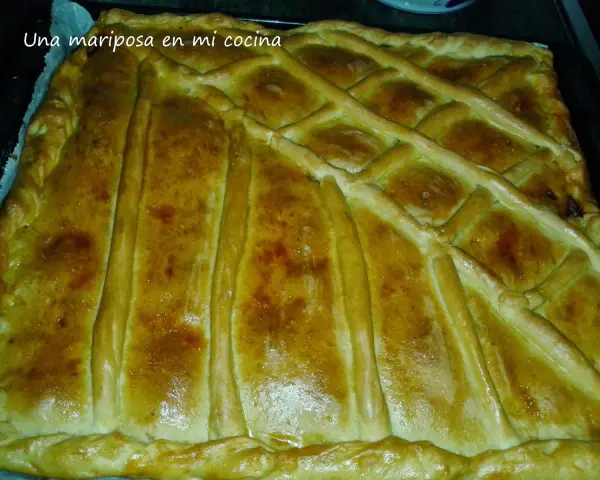 Empanada marinera dorada y crujiente, lista para disfrutar. Su masa cubierta con un enrejado perfecto promete un sabor delicioso.