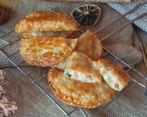 Empanadillas de gambas doradas y crujientes, rellenas de marisco y cremosidad, listas para disfrutar.