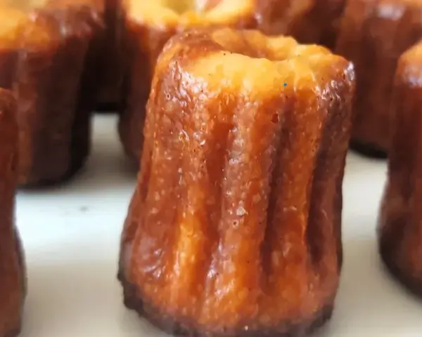 Un grupo de canelés de Bordeaux, con su característica corteza dorada y acanalada, listos para ser disfrutados.