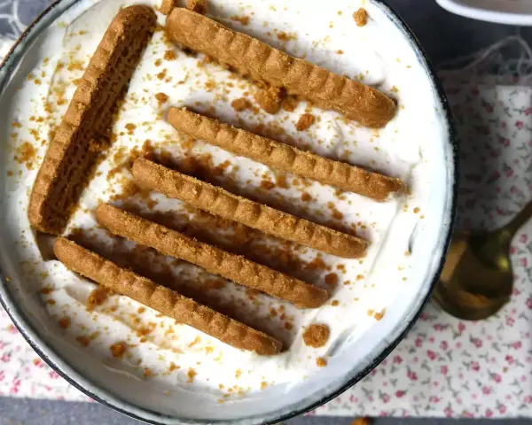 Delicioso postre con yogur natural sin horno, decorado con galletas crujientes y migas.