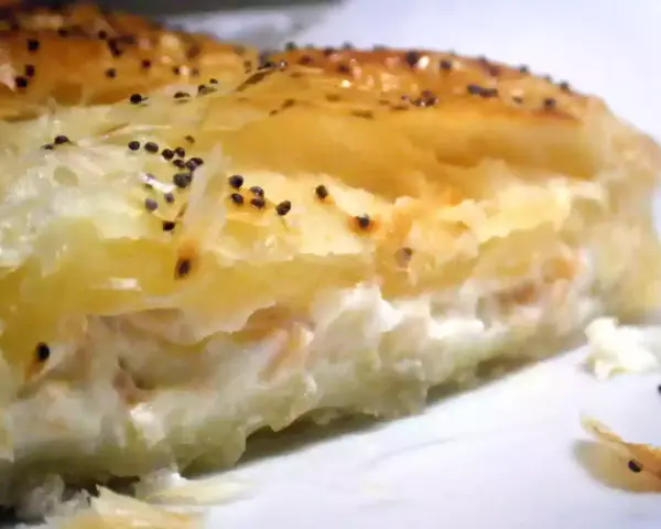 Un trozo de hojaldre de salmón y philadelphia, con semillas de amapola espolvoreadas.