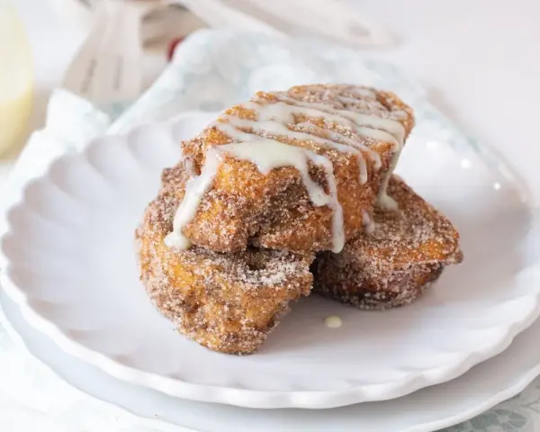 Torrijas doradas y crujientes, espolvoreadas con azúcar y canela, bañadas en dulce leche condensada.