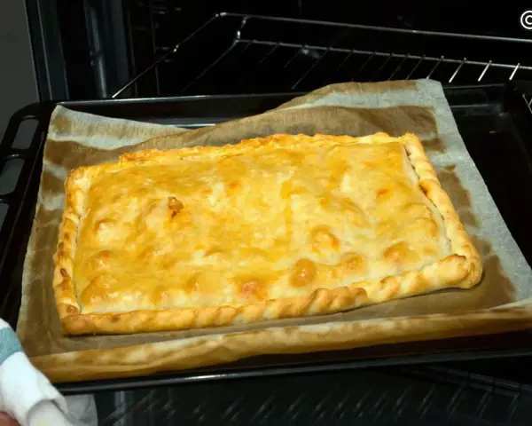 Empanada de zamburiñas recién horneada, dorada y lista para disfrutar.