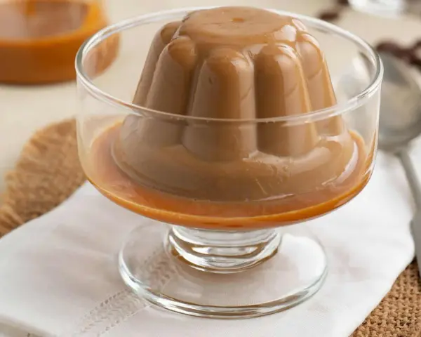 Deliciosa panna cotta de café, con un suave caramelo líquido, servida en copa de cristal.