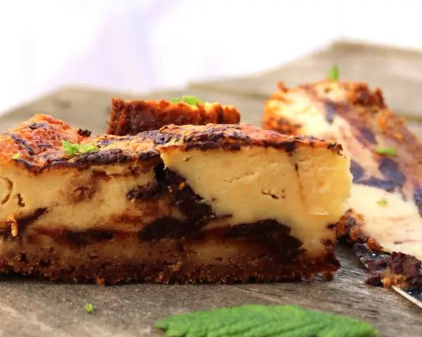 Tarta de queso con chocolate, con trozos de chocolate oscuro y una base crujiente. Perfecta para los amantes del dulce.