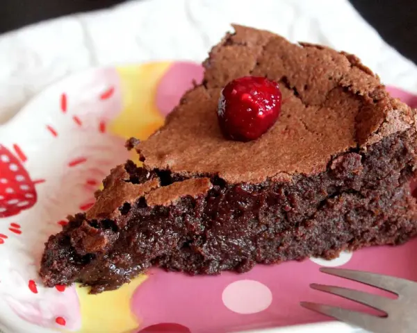 Deliciosa tarta sin gluten y sin lactosa, con un centro fundente y coronada con una frambuesa.