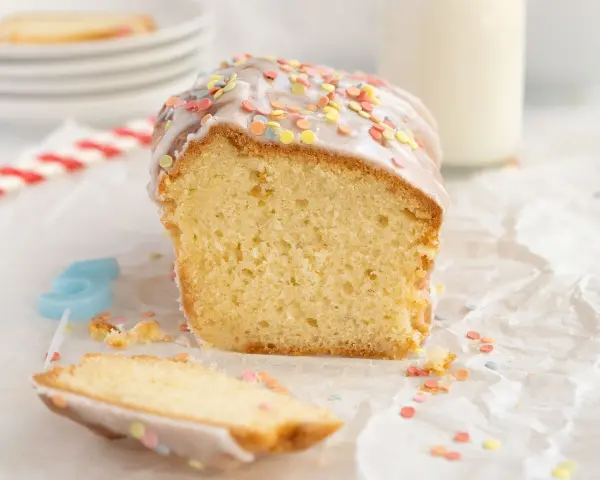 Bizcocho esponjoso hecho en airfryer, cubierto con glaseado y chispas de colores. ¡Perfecto para celebrar!