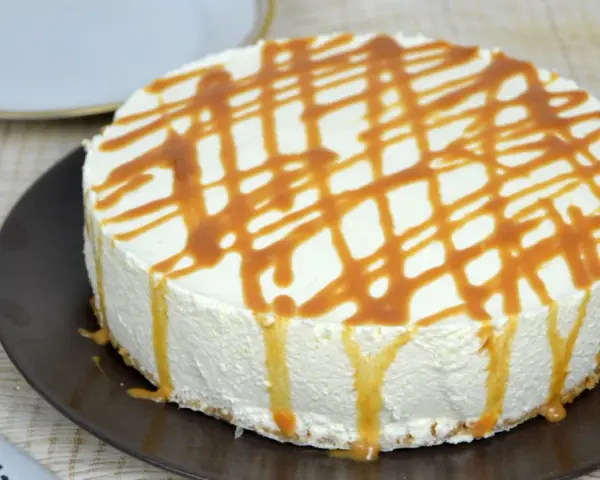 Tarta de queso con leche condensada, cubierta de caramelo líquido, lista para disfrutar.