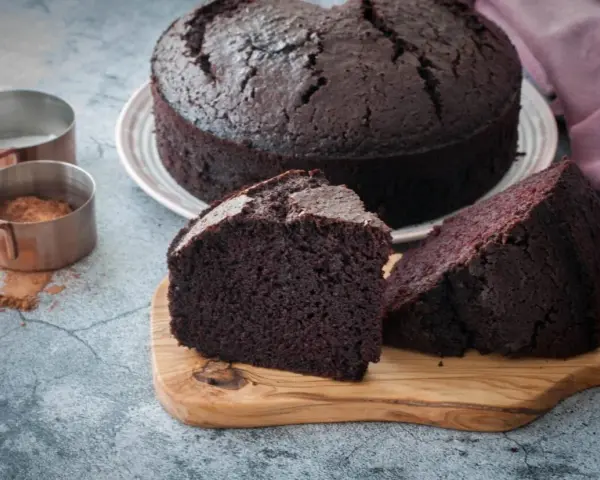 Un delicioso bizcocho de chocolate, recién horneado, con dos porciones listas para disfrutar.