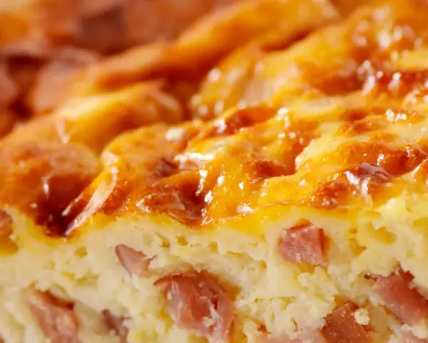 Primer plano de una deliciosa quiche Lorraine, con trozos de bacon y una dorada capa superior. ¡Perfecta para tu próxima receta!