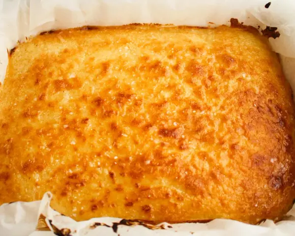 Un delicioso blondie dessert recién horneado, dorado y crujiente, listo para ser cortado y disfrutado.