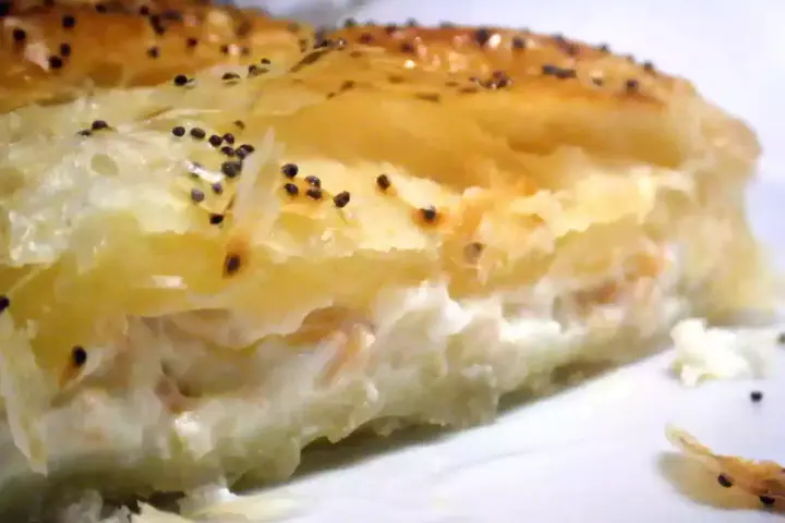 Un trozo de hojaldre de salmón y philadelphia, con semillas de amapola espolvoreadas.