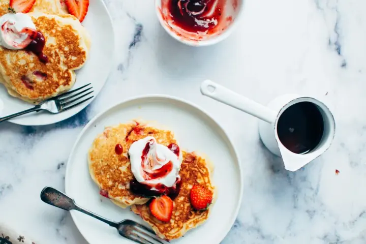 Deliciosas tortitas con fresas y nata, listas para servir. Aprende como hacer tortitas perfectas para el desayuno.