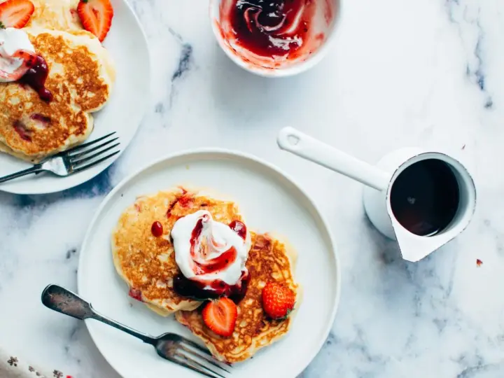 Deliciosas tortitas con fresas y nata, listas para servir. Aprende como hacer tortitas perfectas para el desayuno.