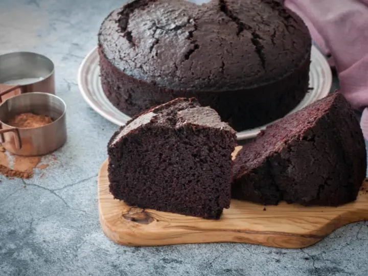 Un delicioso bizcocho de chocolate, recién horneado, con dos porciones listas para disfrutar.