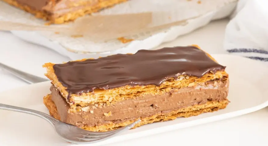 Delicioso milhojas de chocolate con capas crujientes de hojaldre y crema de cacao.
