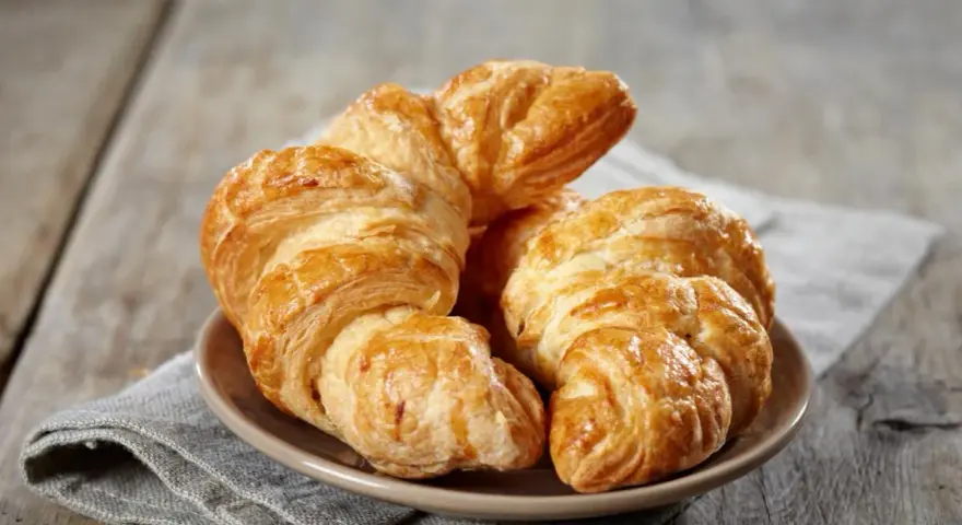 Croissants dorados y hojaldrados, perfectos para tu receta de croissant mantequilla. Un placer crujiente.