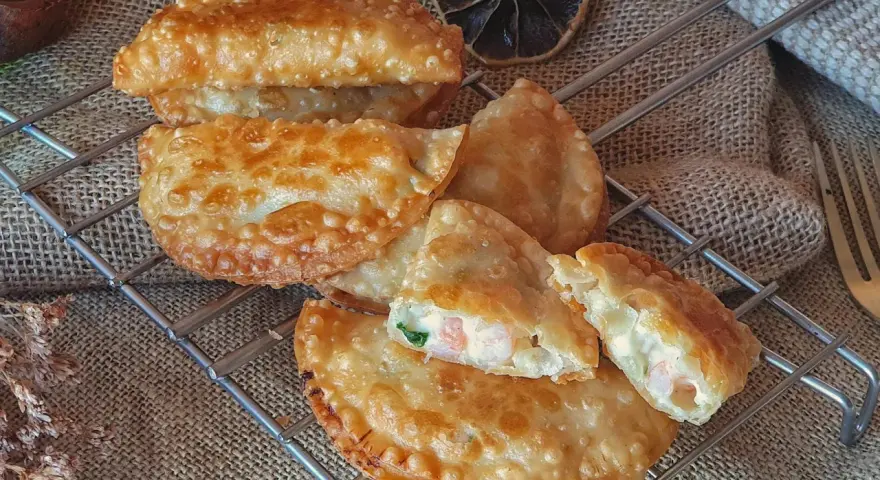 Empanadillas de gambas doradas y crujientes, rellenas de marisco y cremosidad, listas para disfrutar.
