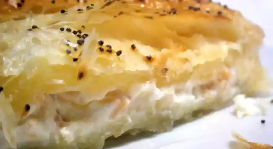 Un trozo de hojaldre de salmón y philadelphia, con semillas de amapola espolvoreadas.