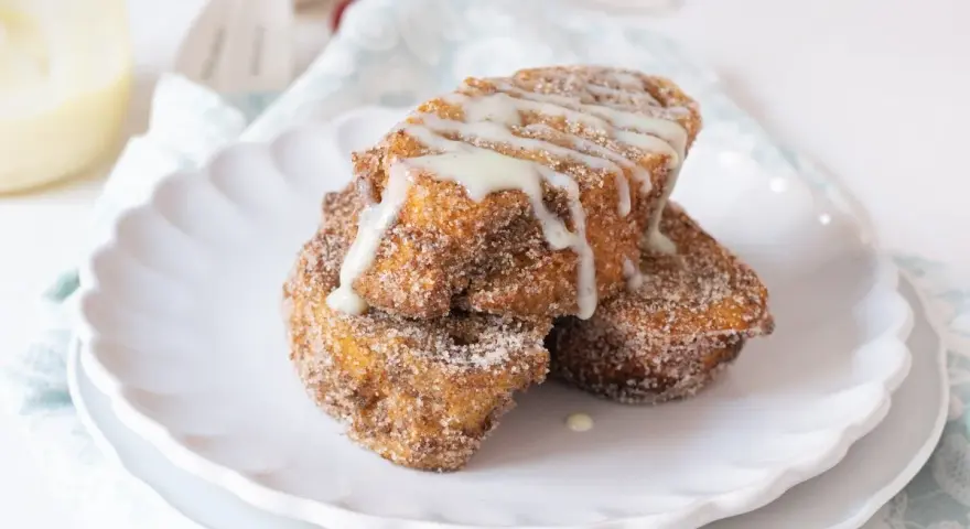 Torrijas doradas y crujientes, espolvoreadas con azúcar y canela, bañadas en dulce leche condensada.