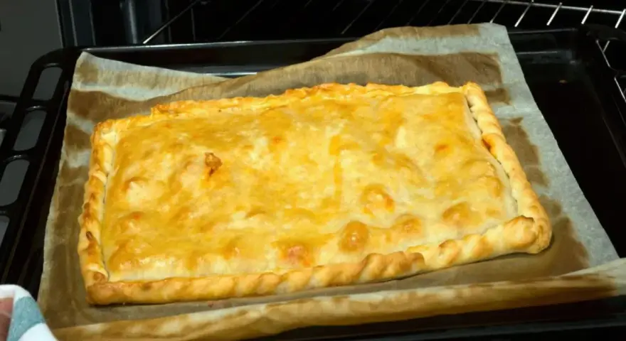 Empanada de zamburiñas recién horneada, dorada y lista para disfrutar.