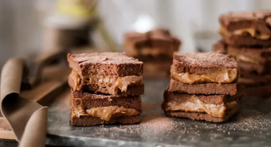 Deliciosos brownie con dátiles, apilados y espolvoreados con cacao. Un dulce placer que te hará soñar.