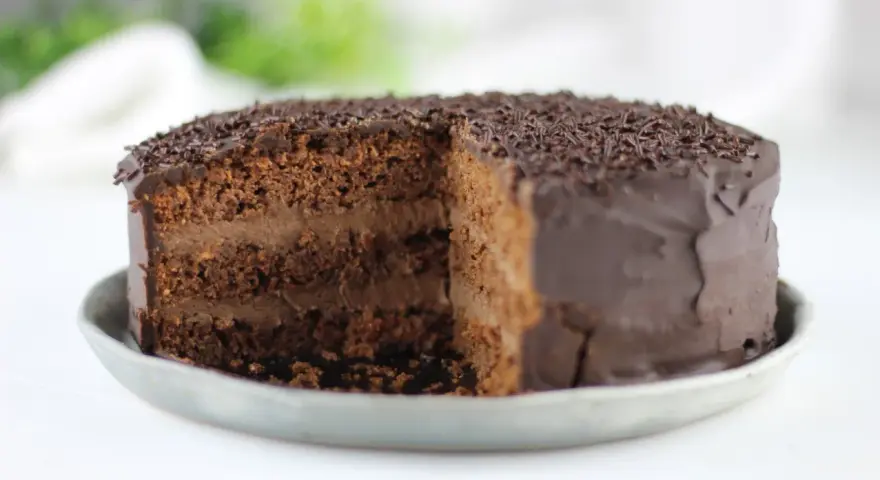 Tarta vegana de chocolate con cobertura brillante y virutas de chocolate. ¡Una delicia para los amantes del cacao!