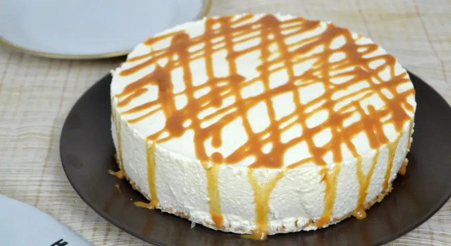 Tarta de queso con leche condensada, cubierta de caramelo líquido, lista para disfrutar.