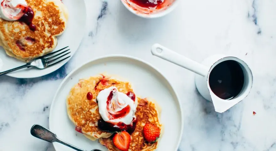 Deliciosas tortitas con fresas y nata, listas para servir. Aprende como hacer tortitas perfectas para el desayuno.