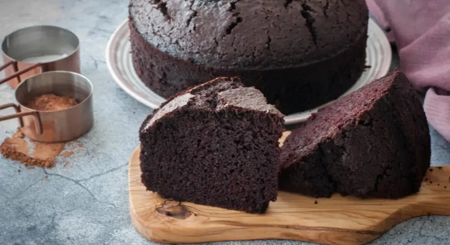 Un delicioso bizcocho de chocolate, recién horneado, con dos porciones listas para disfrutar.
