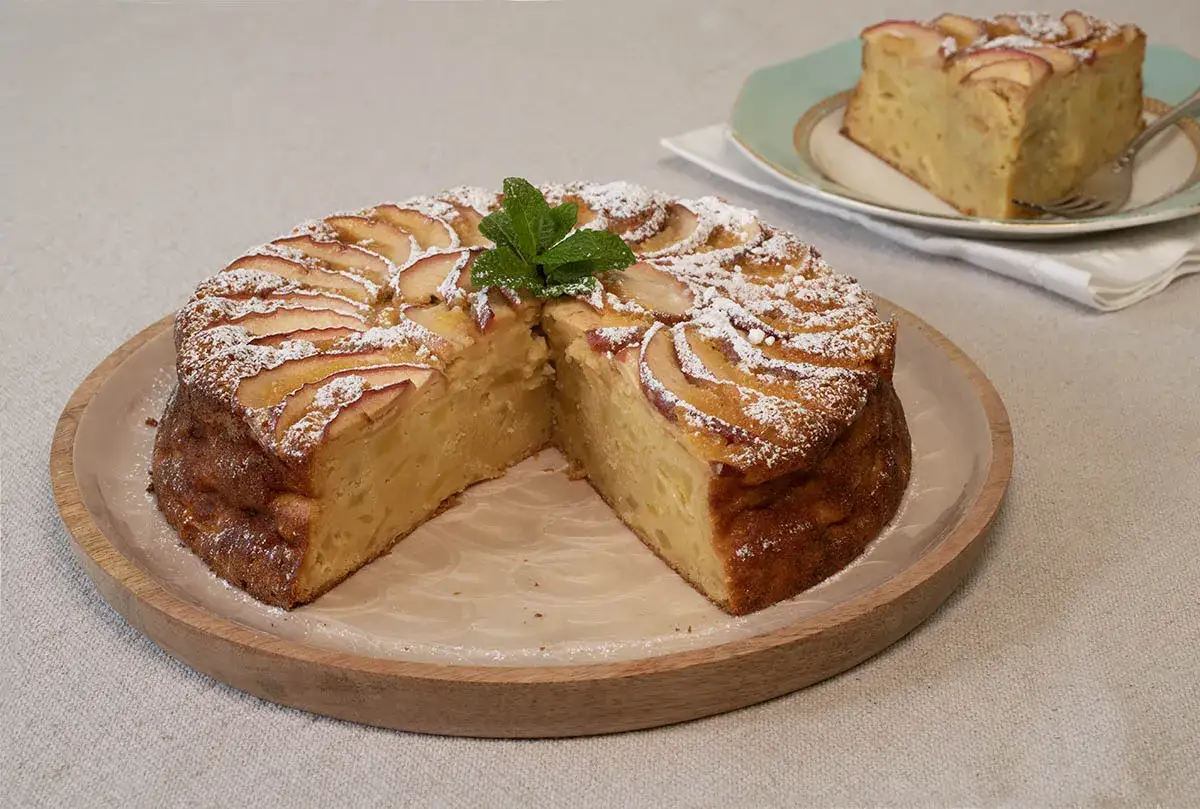 Tarta de manzana con az&uacute;car glas y menta. Un trozo servido en plato, como un tesoro invisible aux pommes.