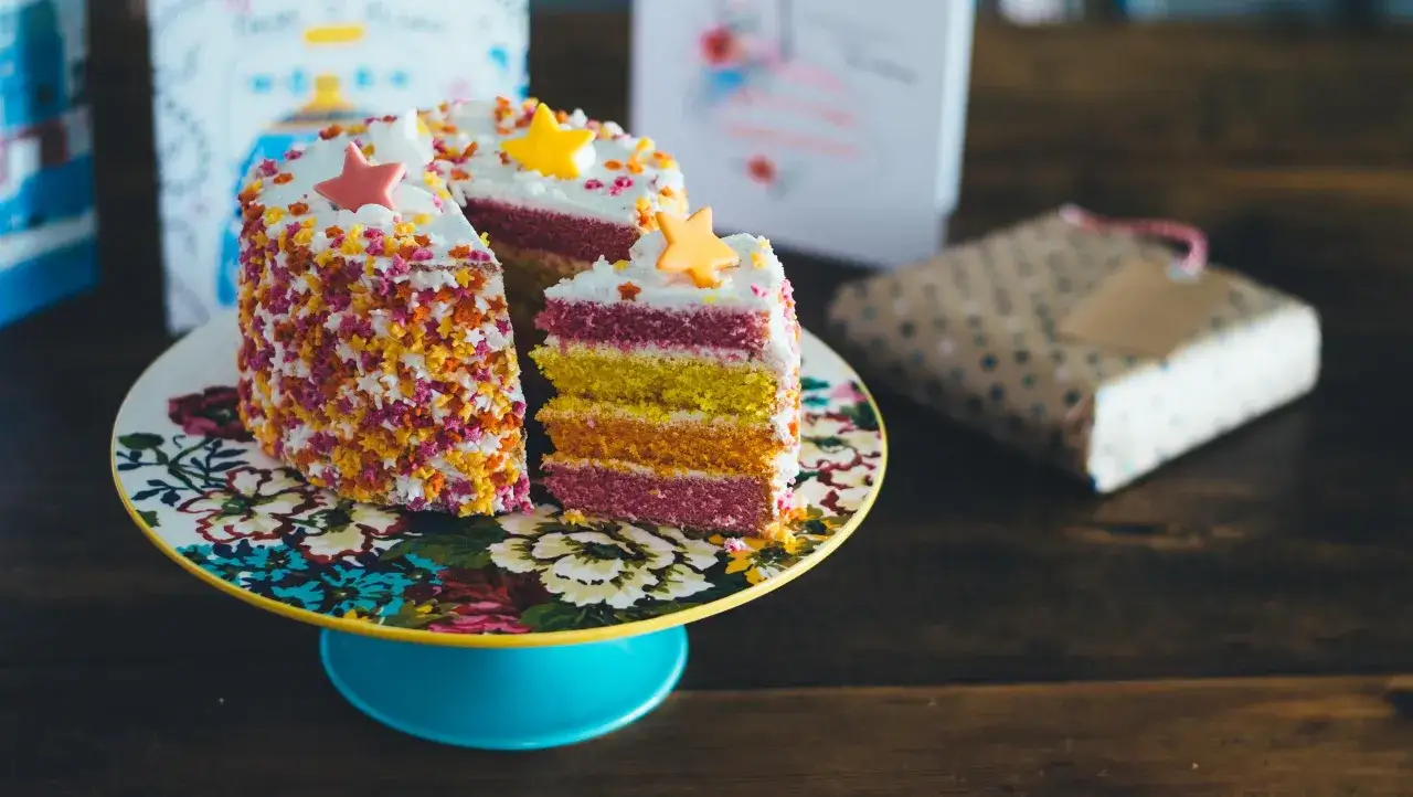 Tarta de cumpleaños multicolor con estrellas, ideal para inspirar recetas de tartas caseras.